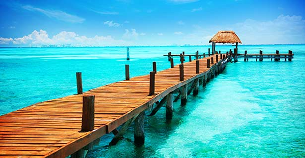 A wooden pier with a hut on top of it.