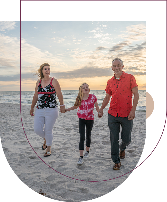 A family walking on the beach holding hands