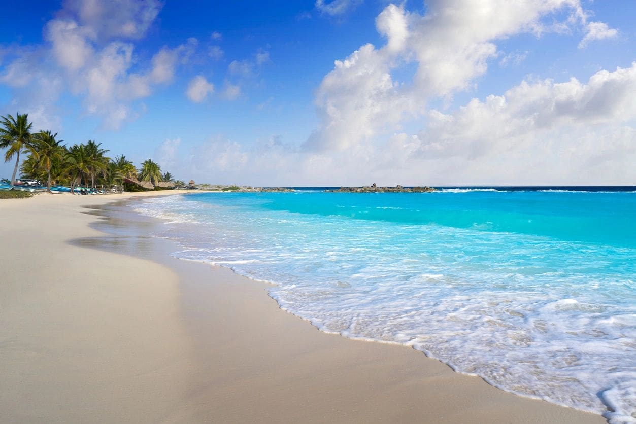 A beach with waves coming in from the ocean.